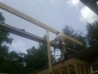 Carpenter setting a ridge beam over a new addition frame — Ice Dam Removal by Roofing Brothers in Tifton