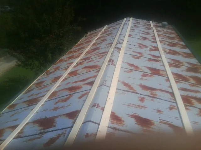 Rusted metal roof panels with new wood purlins before replacement — Storm Damage Roof Repair in Tifton by Roofing Brothers