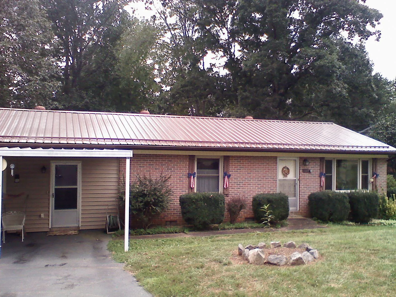 Bronze metal roof and carport on a brick ranch home — Roof Repair work by our crew in Tifton