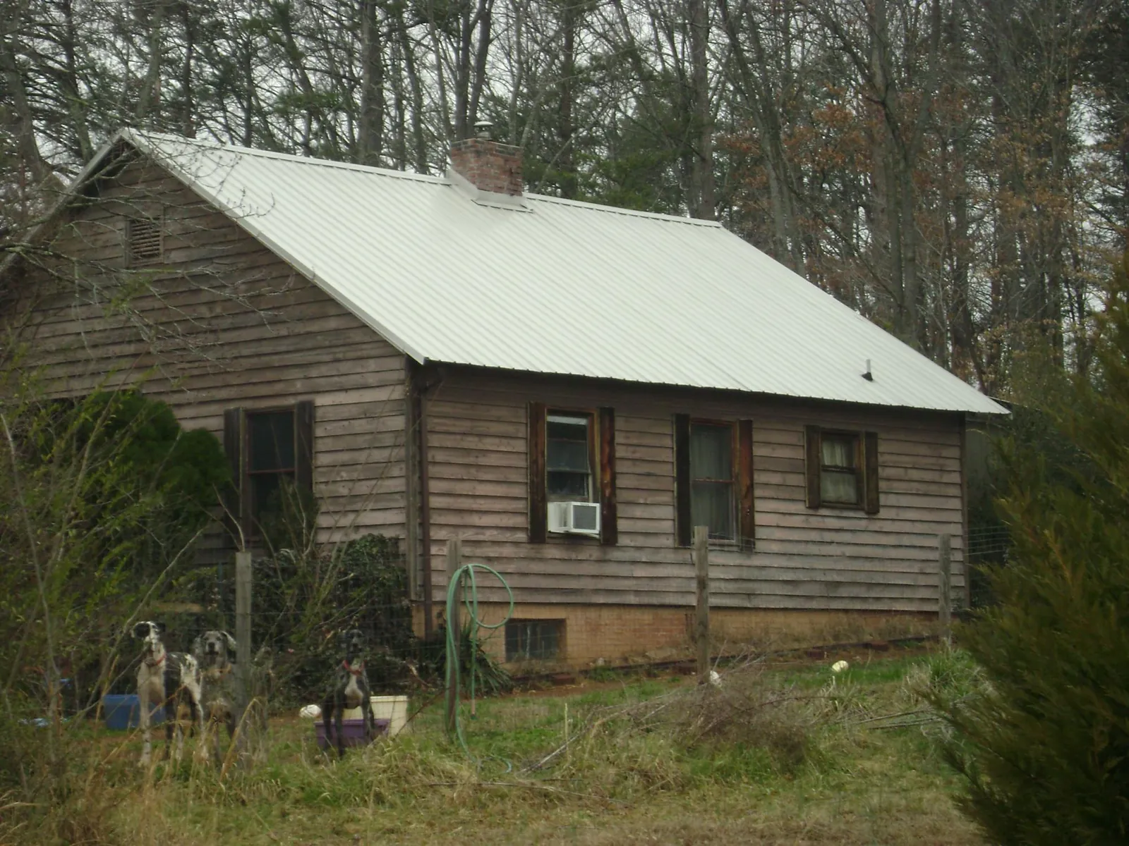 White metal roof on an old wood sided farmhouse, from a Metal Roof Installation job in Tifton